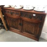 A linen-fold carved side cabinet.