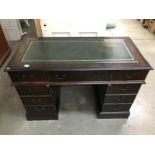A dark wood desk with green leather insert on top.