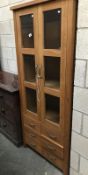 A 2 door 6 drawers wooden cabinet with glazed doors.