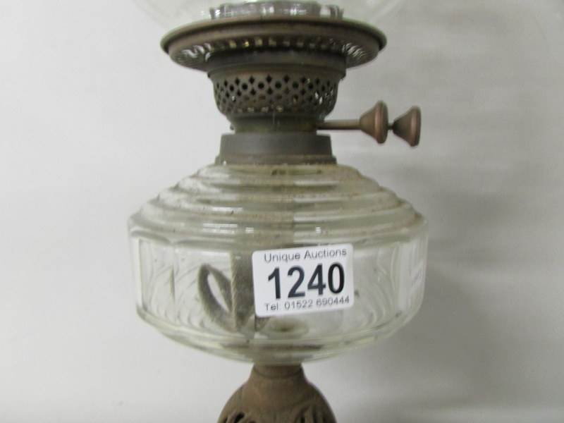 A Victorian oil lamp with clear glass font and floral acid etched shade on a cast iron base. - Image 3 of 4