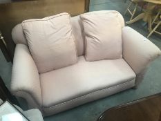 A pink fabric 2 seater drop end settee.