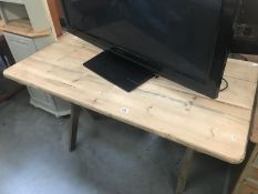 A pine kitchen table with cross leg base.