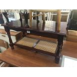 A dark wood stained coffee table with cane shelf.