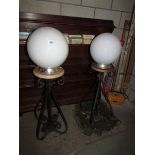 A pair of outdoor lights with globe shades.