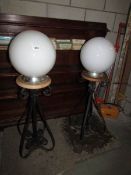 A pair of outdoor lights with globe shades.