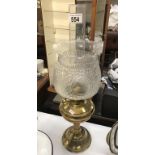 A brass oil lamp with moulded glass shade.