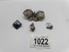 A moveable silver owl, a butterfly brooch, a windmill brooch and a kiwi brooch.