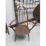 A dark Ercol elbow chair.