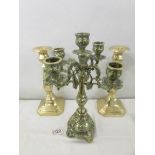 A pair of brass candlesticks and a heavy brass candelabra.