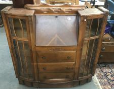 A carved 1930s/40s bureau with glazed side display cabinets.