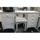 A white dressing table and stool.