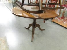 An oak circular tripod table.