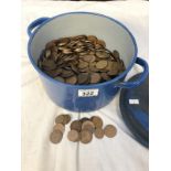 A heavy enamelled metal cooking pot full of coins, mostly pre-decimal pennies.
