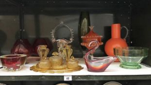 A shelf of art glass including amber glass dressing table set.