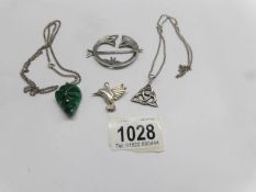 A malachite pendant, a Celtic pendant, both on silver chains, a bird pendant and a brooch.