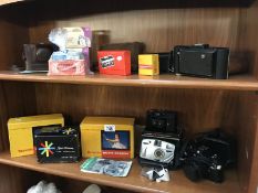 A quantity of vintage cameras and other photographic equipment (2 shelves).