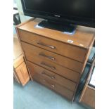 A teak 5 drawer chest of drawers.