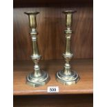 A pair of Victorian brass candlesticks with pushers.