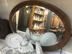 A large oval oak framed bevel edged mirror.