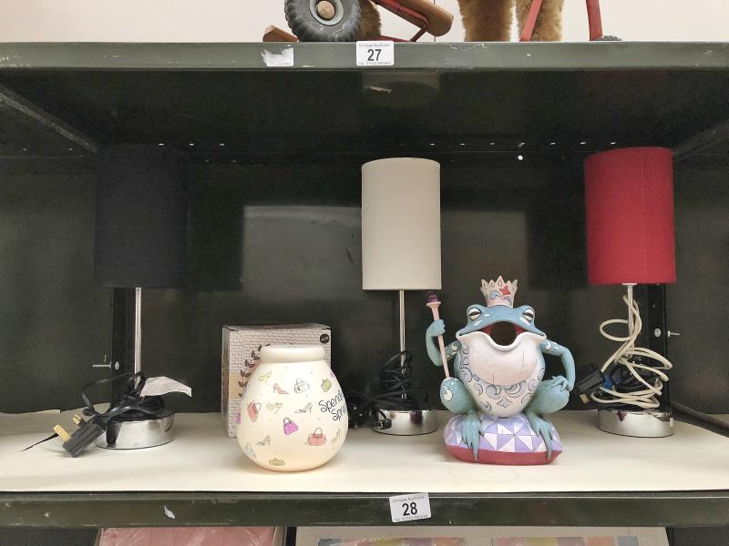 A shelf of table lamps etc. including a frog money box.