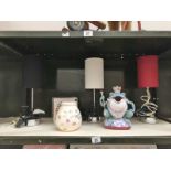 A shelf of table lamps etc. including a frog money box.