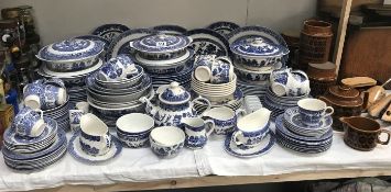 A large quantity of blue willow dinnerware including Hornsea storage jars and teapot.