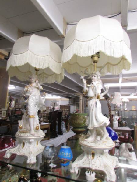 A pair of impressive gilded figural table lamps with shades.