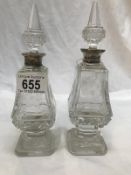 A pair of glass scent bottles with silver collars.
