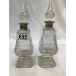 A pair of glass scent bottles with silver collars.