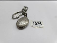 A large old silver locket on heavy silver chain.