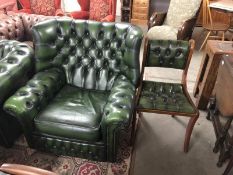 A green leather wing arm chair and matching dining chair,