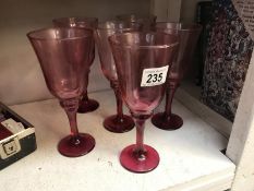 A set of 6 cranberry glass wine goblets.