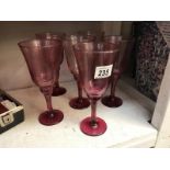 A set of 6 cranberry glass wine goblets.