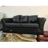 A black leather 2/3 seater sofa.