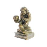 A metal table lighter in the form of a monkey modelled on 'The Thinker'.