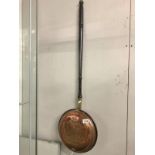 A Victorian copper warming pan with engraved lid.