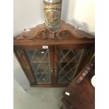 A glazed corner wall shelf cupboard.