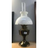 A brass aladdin oil lamp with shade and chimney.