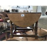 A small oak drop leaf swivel top coffee table.