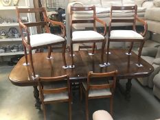 An extending mahogany dining table with 2 leaves and 7 chairs.