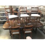 An extending mahogany dining table with 2 leaves and 7 chairs.