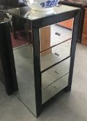 A 4 drawer bevelled mirror chest of drawers.