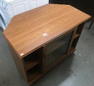 A teak effect glazed corner TV stand.