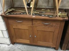 A wooden 2 drawer 2 door cabinet.