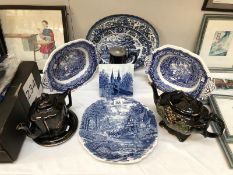 A quantity of blue and white and back pottery including platters and tea pots.