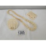3 items of bone jewellery being a necklace, a brooch and a buckle.