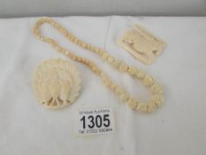 3 items of bone jewellery being a necklace, a brooch and a buckle.