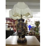 A gilded pottery table lamp with shade.