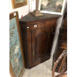 A Georgian oak corner cupboard with painted interior and key.