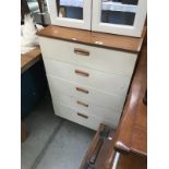 A teak effect chest with white drawer front.